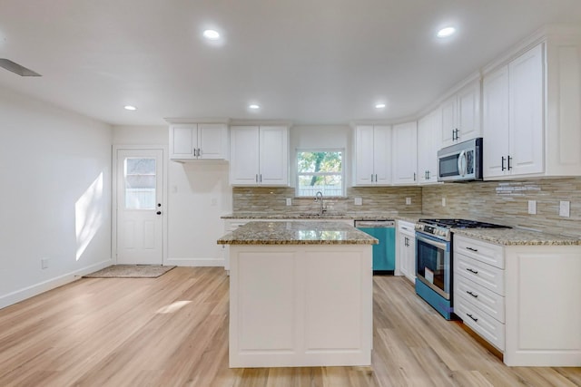 kitchen featuring light stone countertops, light hardwood / wood-style flooring, stainless steel appliances, and white cabinets