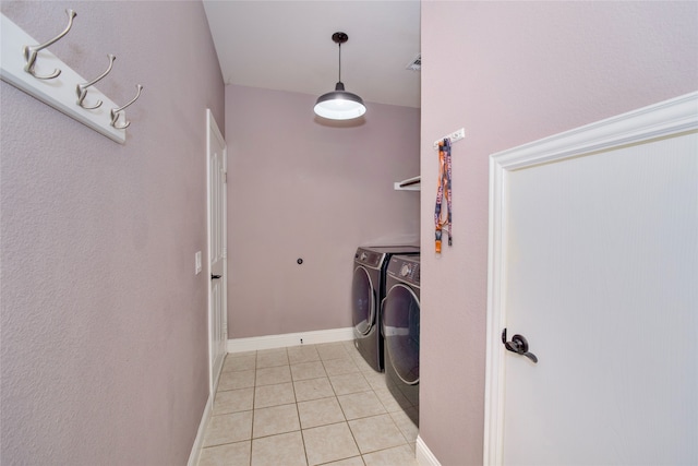 laundry room featuring washer and clothes dryer and light tile patterned floors