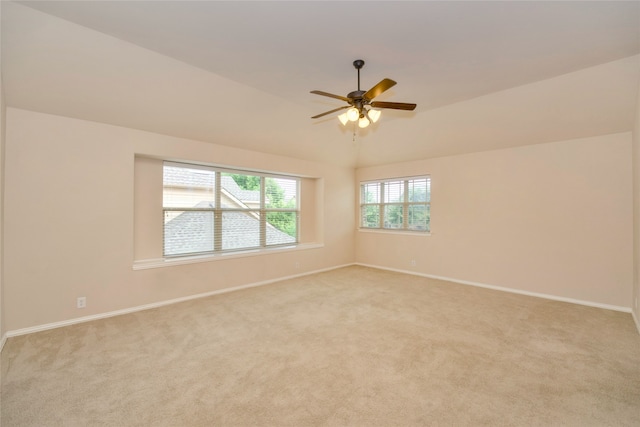 carpeted empty room featuring vaulted ceiling and ceiling fan