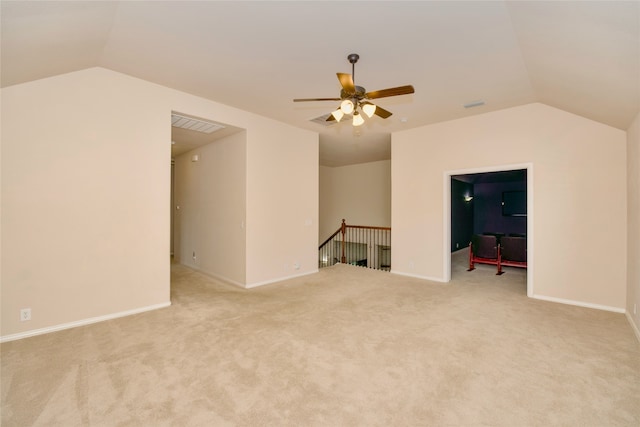 empty room featuring ceiling fan, vaulted ceiling, and light carpet