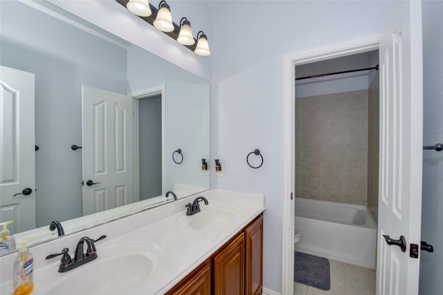 full bathroom with tiled shower / bath, tile patterned floors, vanity, and toilet