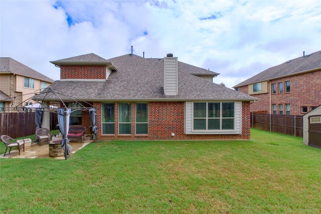 back of property with a gazebo, a patio, and a lawn