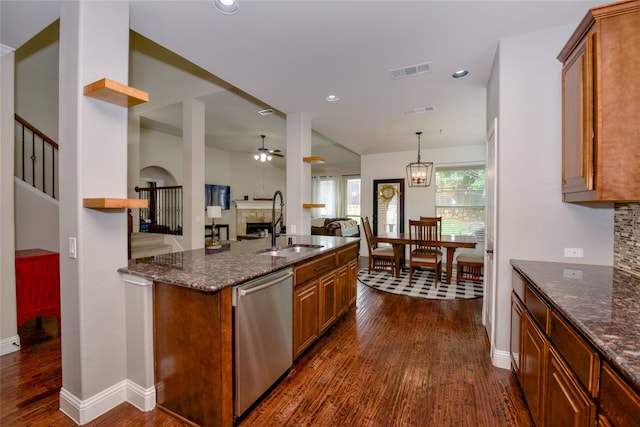 kitchen featuring dark hardwood / wood-style flooring, dark stone counters, sink, and dishwasher