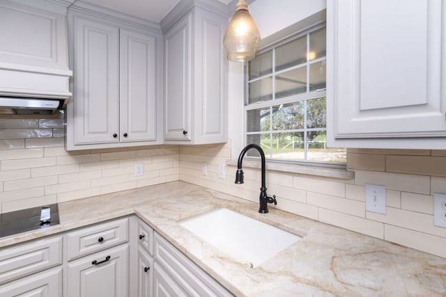 kitchen featuring white cabinets, pendant lighting, and sink