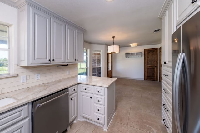 kitchen with kitchen peninsula, decorative light fixtures, appliances with stainless steel finishes, crown molding, and decorative backsplash