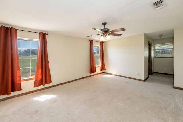 carpeted spare room featuring ceiling fan