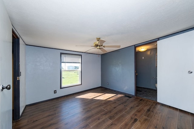 empty room featuring ceiling fan, a textured ceiling, and dark hardwood / wood-style floors