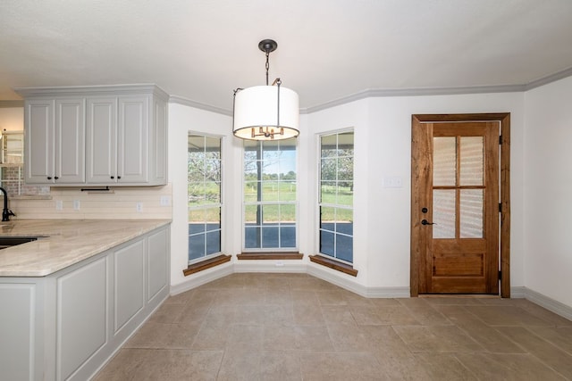 unfurnished dining area featuring ornamental molding and sink