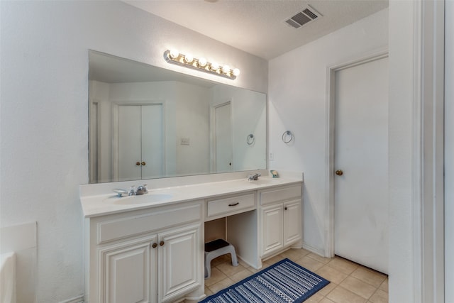 bathroom featuring vanity, a textured ceiling, and tile patterned floors