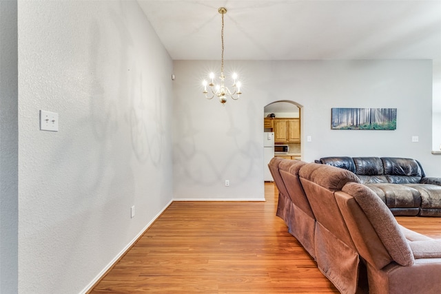 living room featuring a chandelier and light wood-type flooring