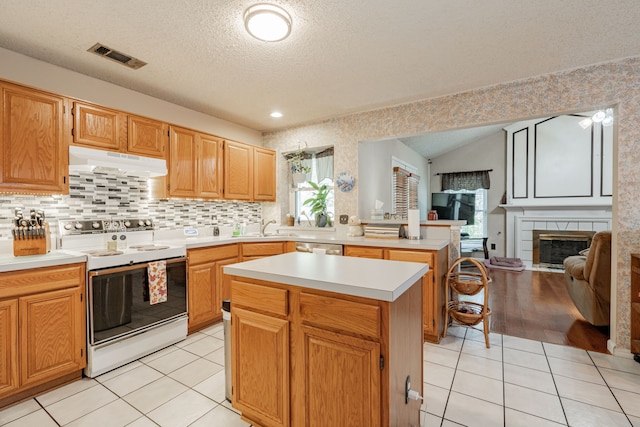 kitchen with a center island, white electric range, a tiled fireplace, vaulted ceiling, and a textured ceiling