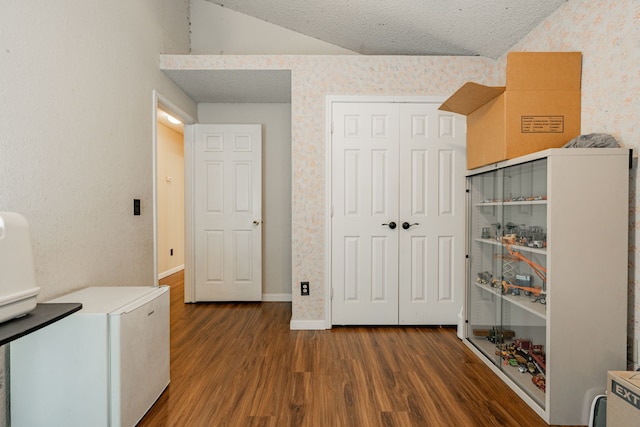 laundry room featuring dark hardwood / wood-style floors and a textured ceiling