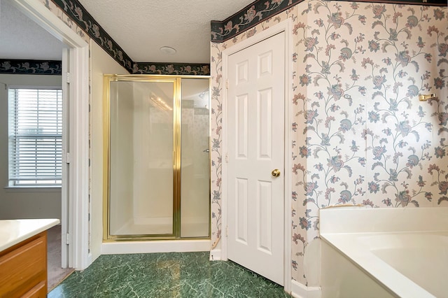 bathroom featuring separate shower and tub, vanity, and a textured ceiling