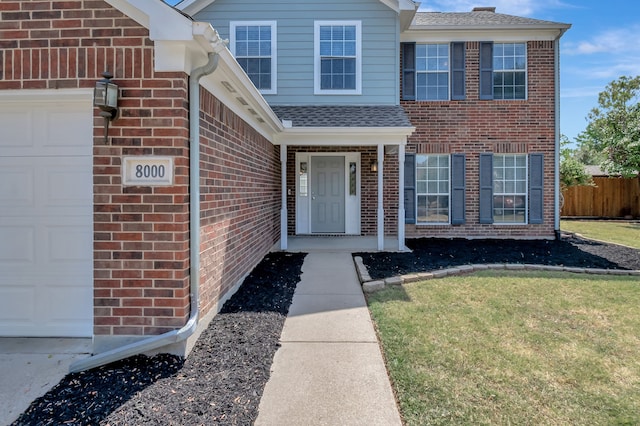 entrance to property with a yard and a garage