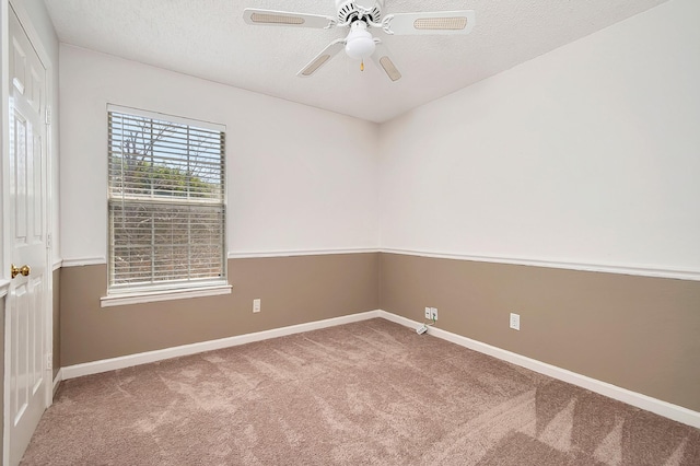 carpeted empty room with ceiling fan and a textured ceiling