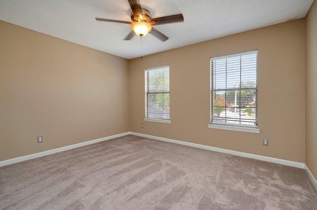 empty room with light carpet, ceiling fan, and a textured ceiling