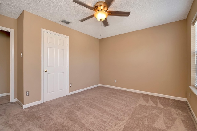 unfurnished bedroom featuring a textured ceiling, ceiling fan, and carpet floors