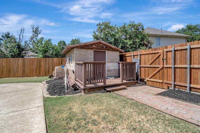 wooden terrace with an outdoor structure and a yard