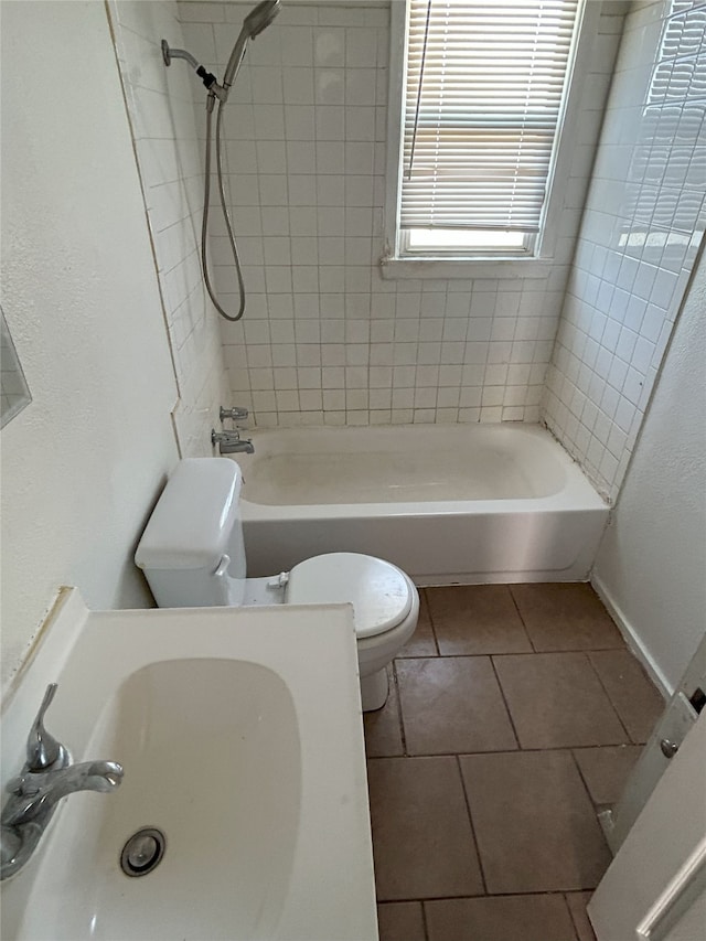 full bathroom featuring tile patterned floors, toilet, sink, and tiled shower / bath combo