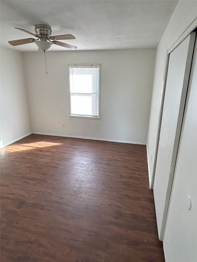 empty room featuring ceiling fan and dark wood-type flooring