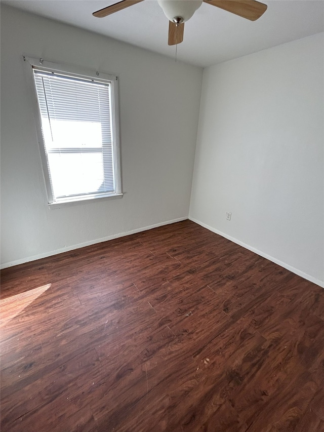 empty room with dark hardwood / wood-style flooring and ceiling fan