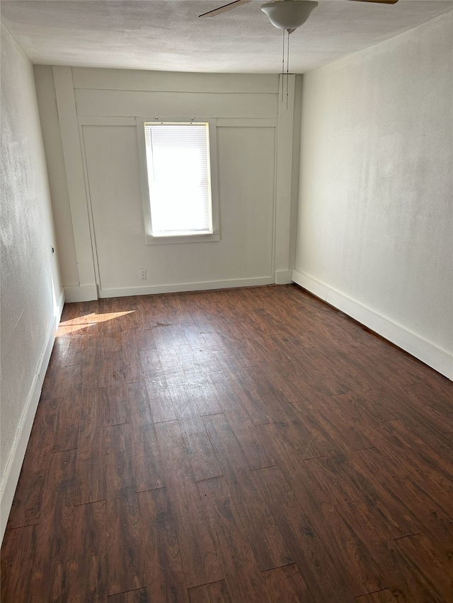 empty room featuring dark wood-type flooring and ceiling fan