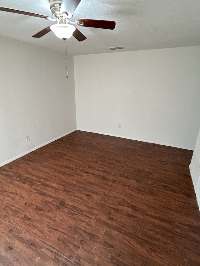 empty room with ceiling fan, dark hardwood / wood-style floors, and a textured ceiling