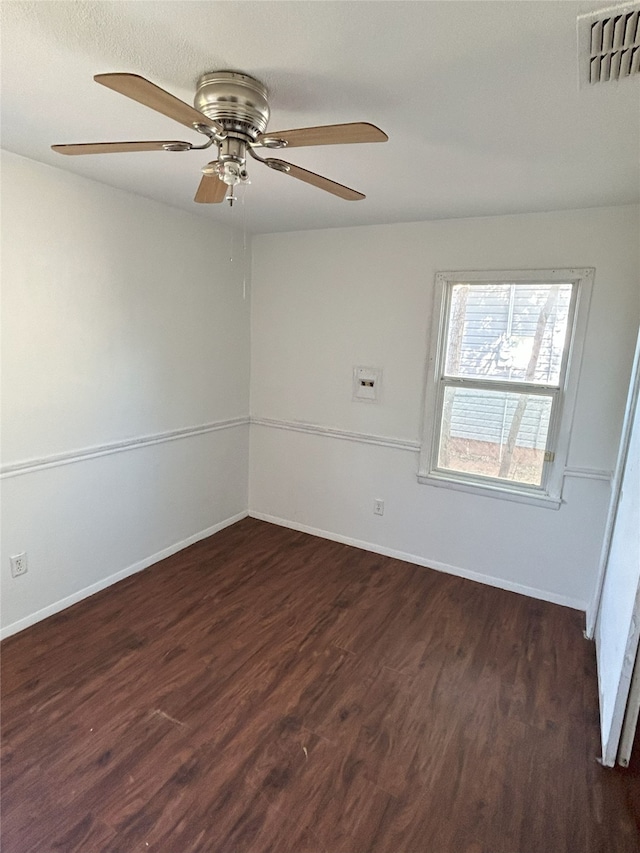 spare room with dark wood-type flooring and ceiling fan