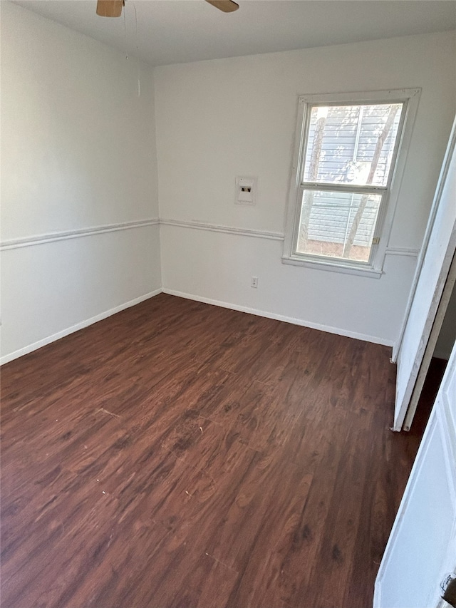 spare room featuring dark wood-type flooring and ceiling fan