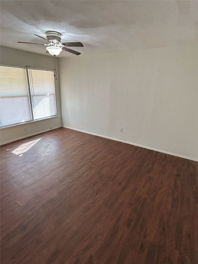 empty room featuring dark wood-type flooring, ceiling fan, and a textured ceiling