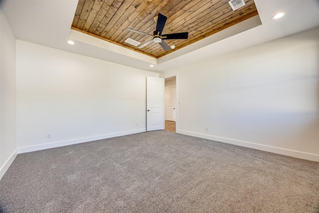 carpeted empty room featuring a raised ceiling, ceiling fan, and wood ceiling