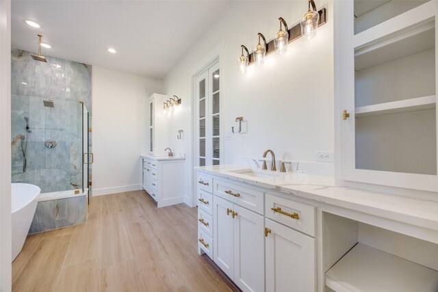 bathroom featuring wood-type flooring, vanity, and separate shower and tub