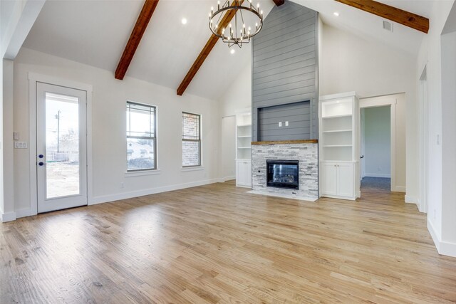 unfurnished living room featuring a fireplace, high vaulted ceiling, an inviting chandelier, and beamed ceiling