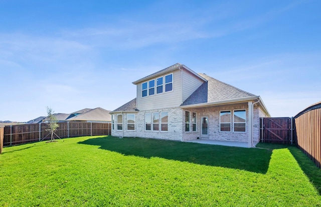 rear view of house featuring a yard and a patio