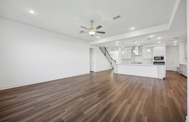 unfurnished living room with ceiling fan, dark hardwood / wood-style flooring, and sink