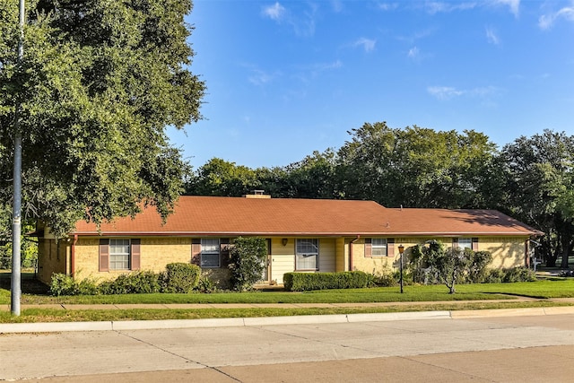 single story home featuring a front lawn