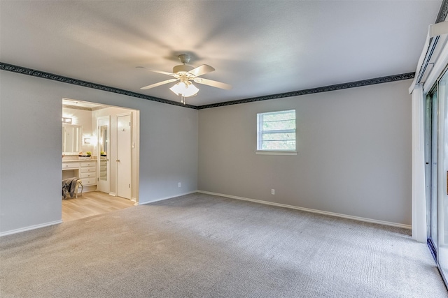 unfurnished bedroom with ceiling fan, light colored carpet, and ensuite bath