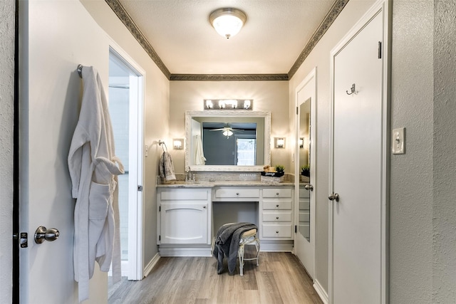 bathroom with hardwood / wood-style flooring, vanity, and a textured ceiling