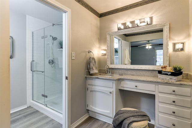 bathroom featuring ceiling fan, a shower with door, vanity, and wood-type flooring