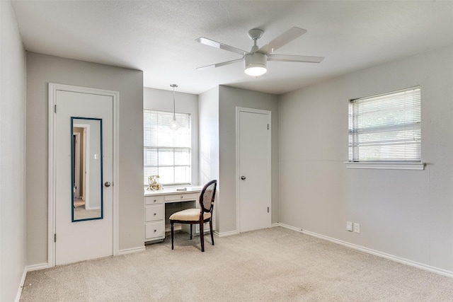 office space with ceiling fan and light carpet