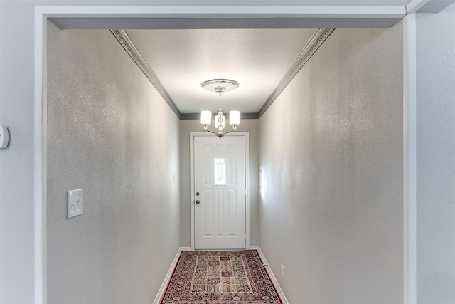 entryway featuring a chandelier and crown molding