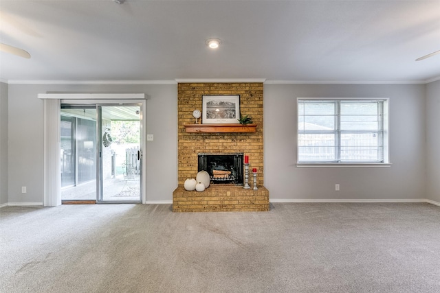 unfurnished living room with carpet flooring, ornamental molding, a brick fireplace, and a healthy amount of sunlight