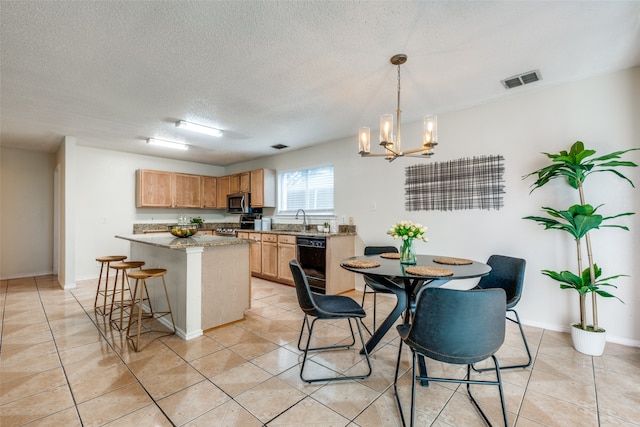 tiled dining area featuring a chandelier, a textured ceiling, and sink