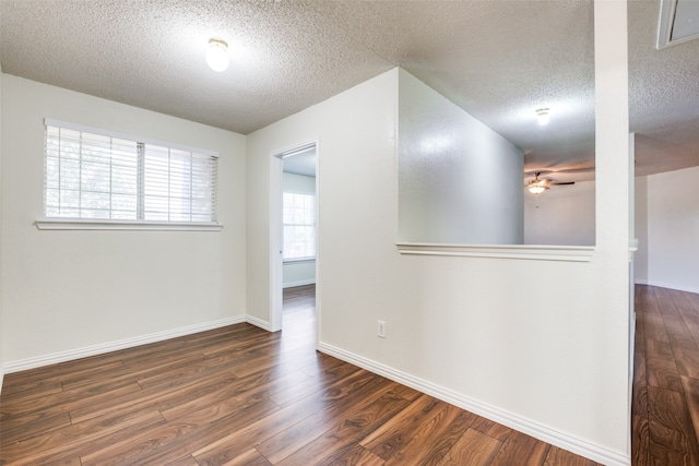 unfurnished room with a textured ceiling, dark hardwood / wood-style flooring, and ceiling fan