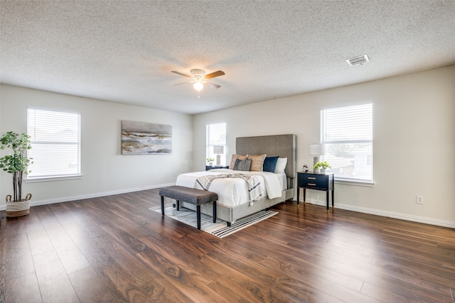 bedroom with multiple windows, ceiling fan, and dark wood-type flooring