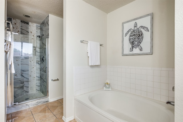 bathroom with tile patterned flooring, a textured ceiling, and separate shower and tub