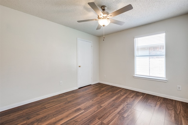 empty room featuring a textured ceiling, dark hardwood / wood-style floors, and ceiling fan