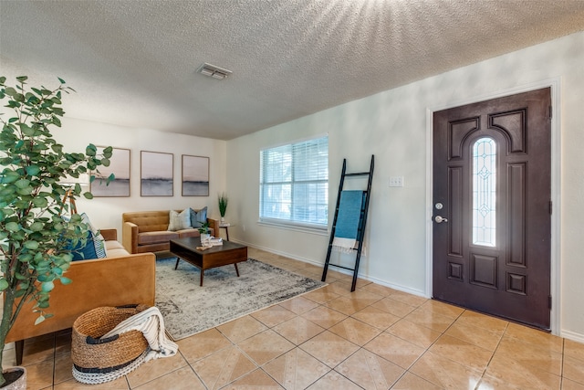 foyer entrance featuring light tile patterned floors and a textured ceiling