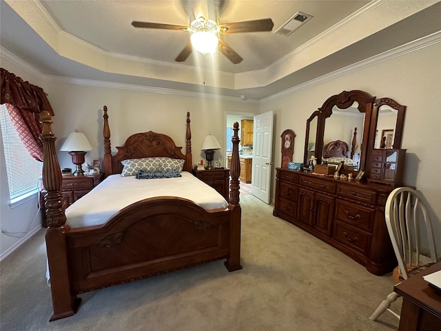 bedroom with a raised ceiling, visible vents, light colored carpet, and ornamental molding