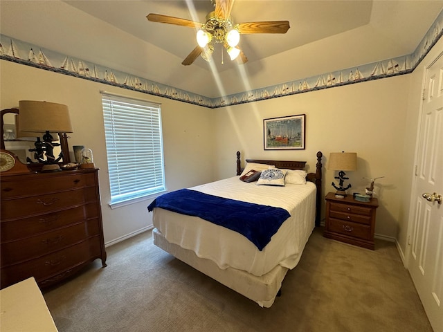 carpeted bedroom featuring baseboards and a ceiling fan